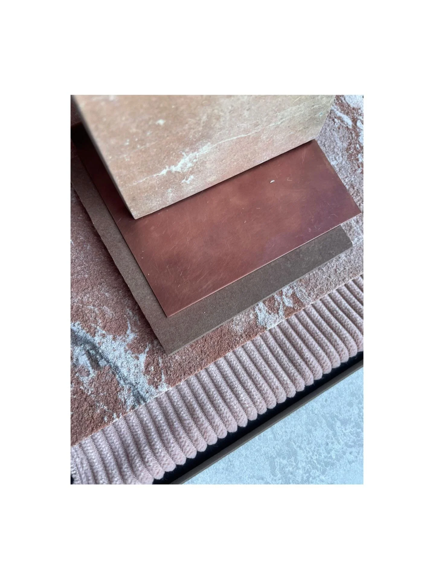 A study in contrast and character.

Rosy marbled stone with an organic, imperfect edge meets the softness of velvet upholstery. Concrete tiles ground the space, while aged copper metalwork adds a quiet warmth. Here each element is chosen for both tac