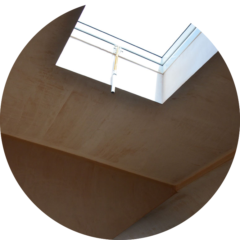 Interior view of a ceiling with a skylight window and a pipe hanging from it.
