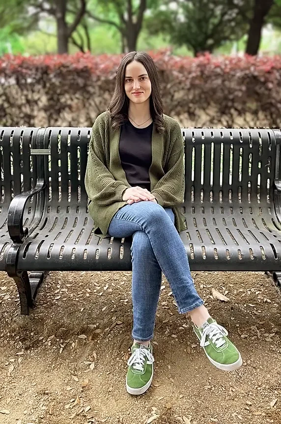 Licensed therapist, Reagan Hylton, sitting on a park bench.