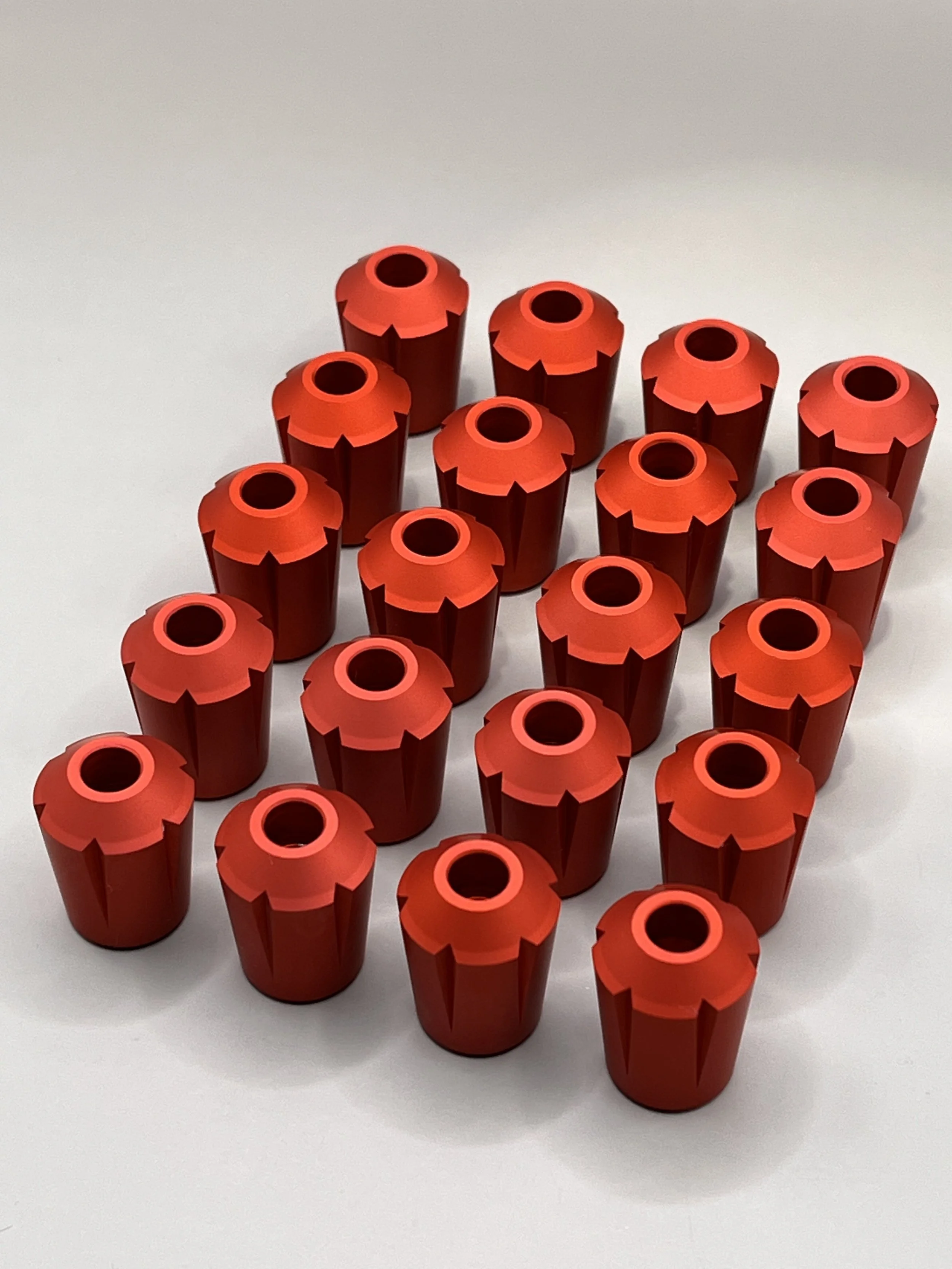 Red aluminium chuck keys arranged in a grid pattern on a white background.