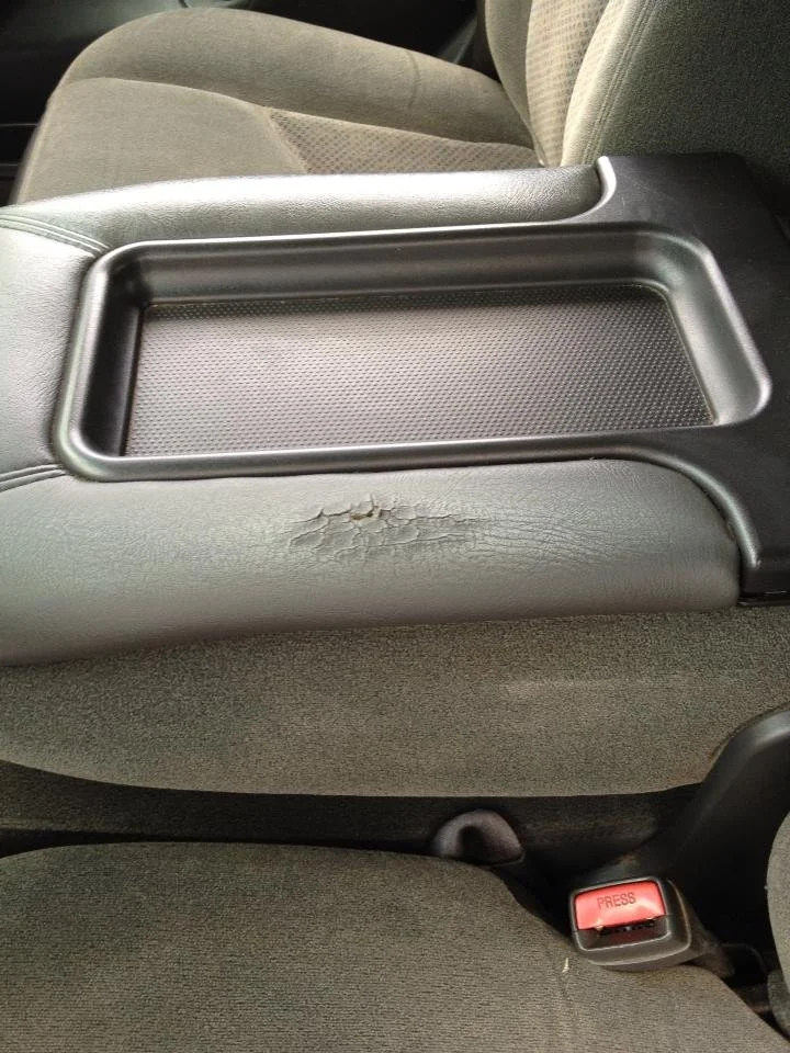 damaged center console of vehicle, black and grey vinyl