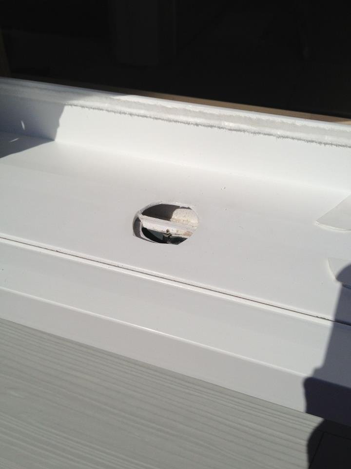 Hail damaged exterior vinyl window frame on a house