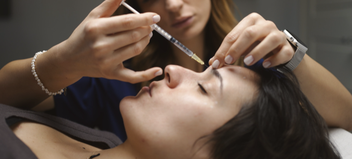 Personale medico che somministra un'iniezione a una donna distesa su un lettino