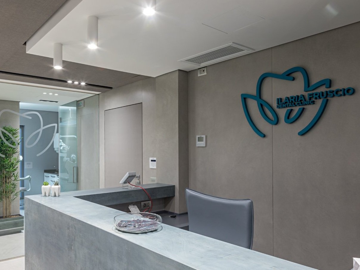 Reception dell'odontoiatria con logo Laria Fruscino Dental Clinic sulla parete