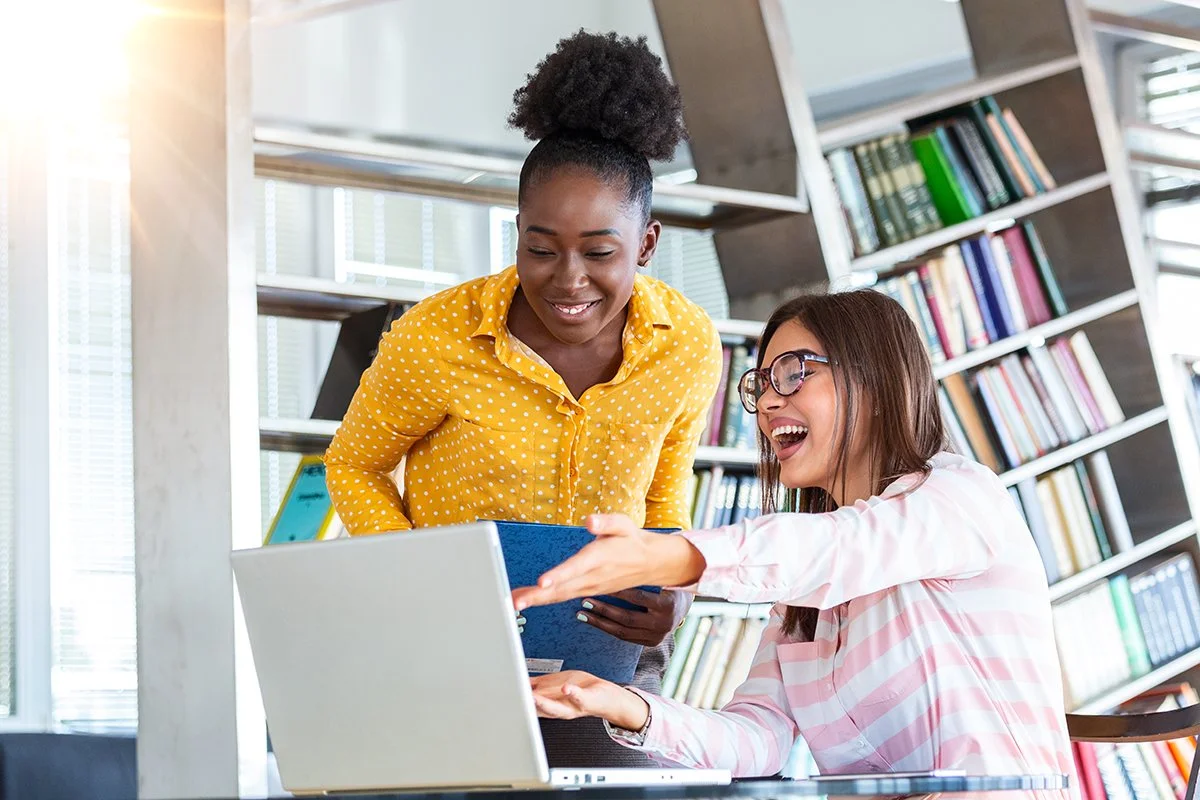 two professionals working on a laptop