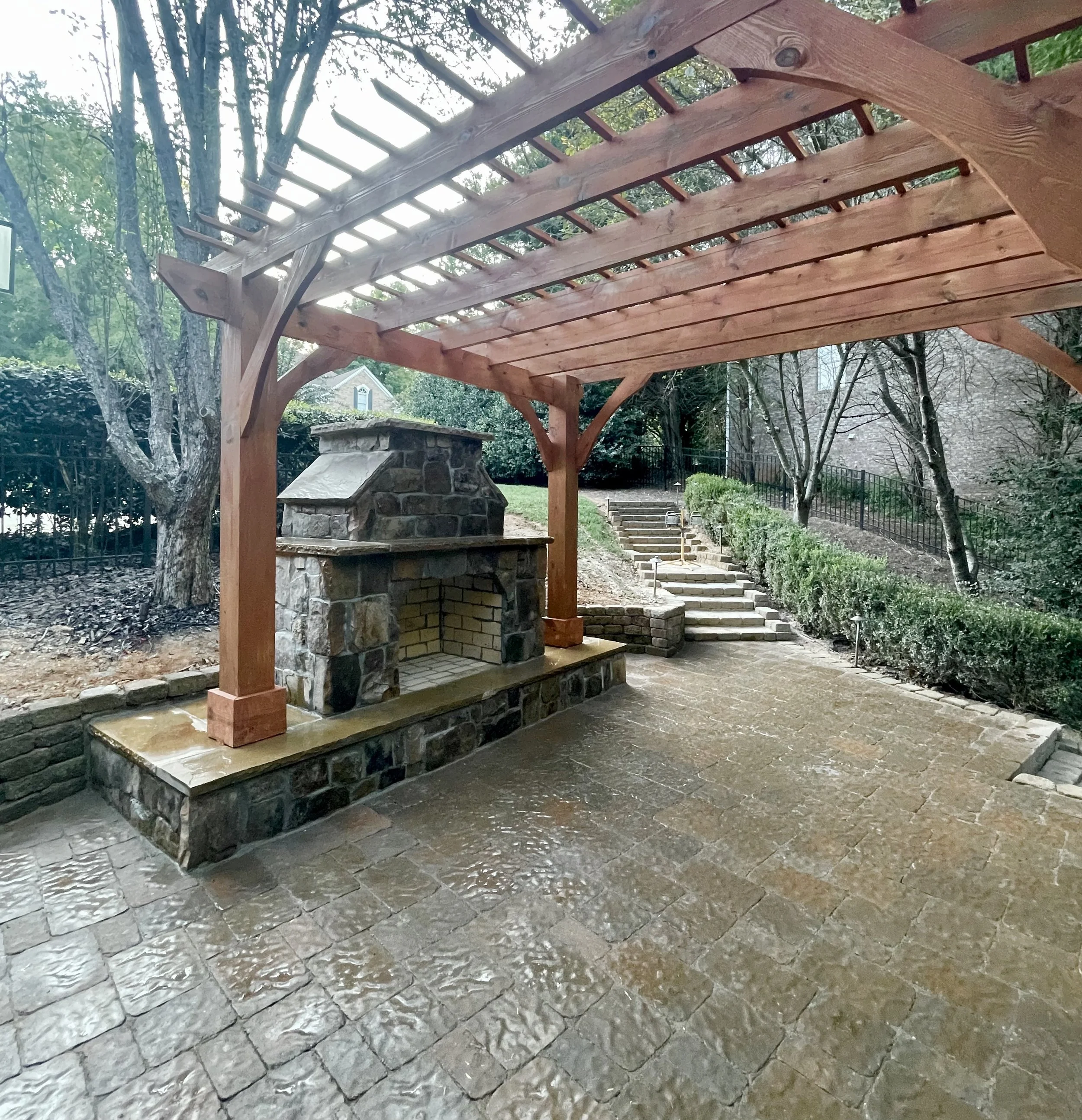 Large fireplace and patio with a cherry color pergola.