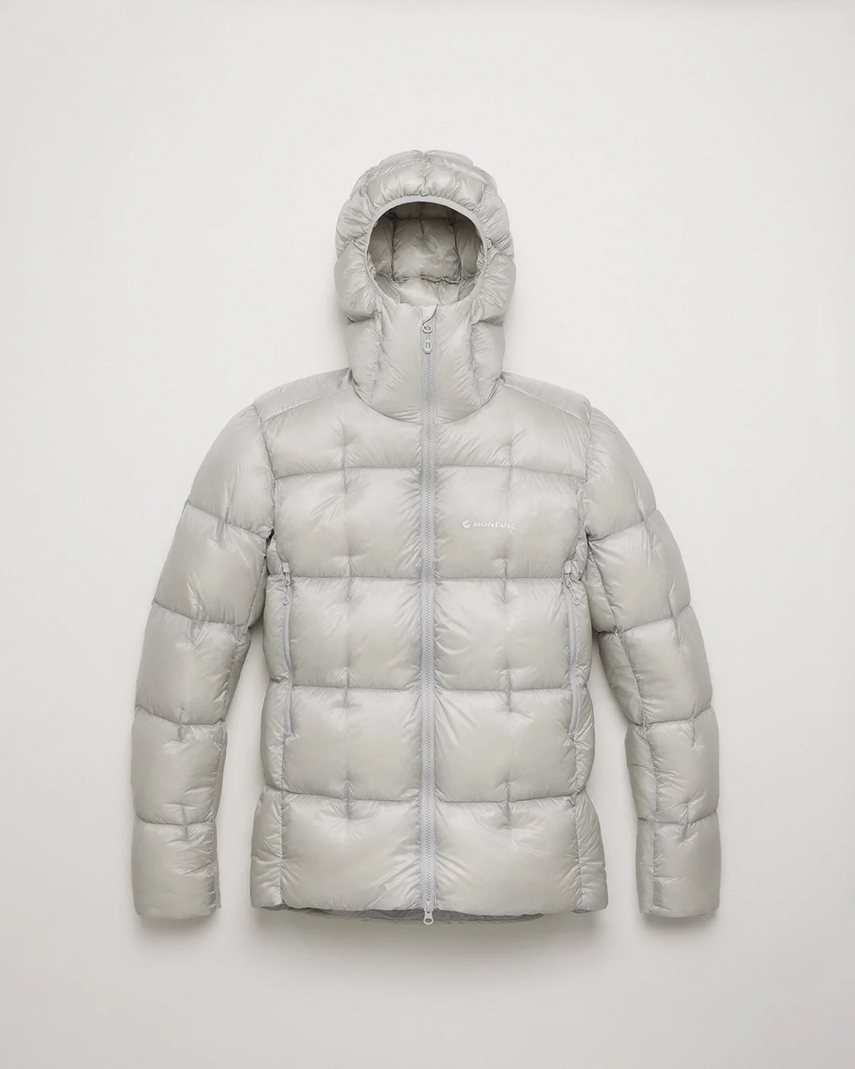 Light gray puffy winter jacket with a hood and front zipper, hanging on a white wall.