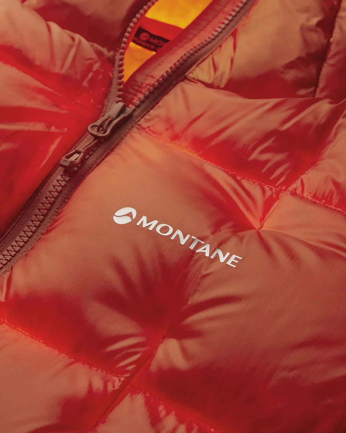 Close-up of a red Montane puffer jacket with a zipper.