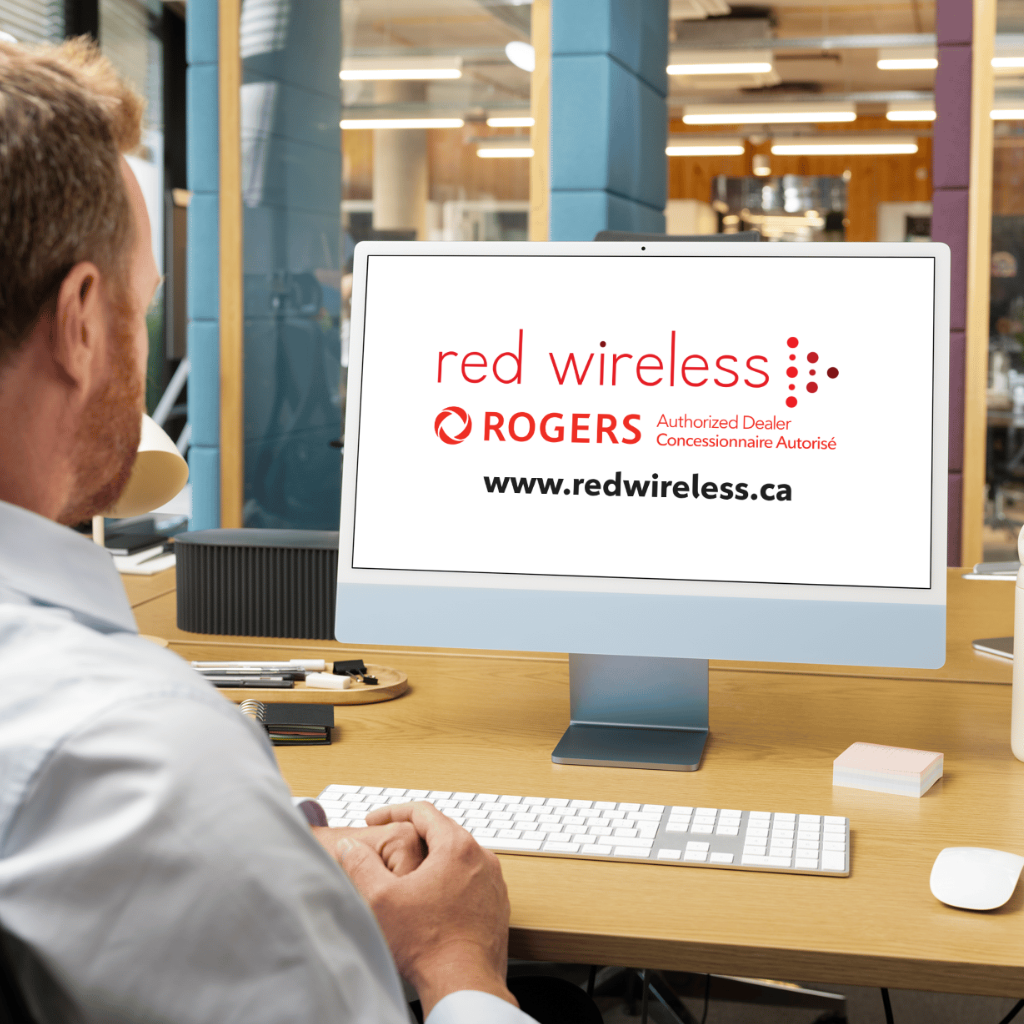 A man at his computer, on screen their is a Red Wireless logo, a Rogers Authorized Dealer Logo, and text that reads www.redwireless.ca.