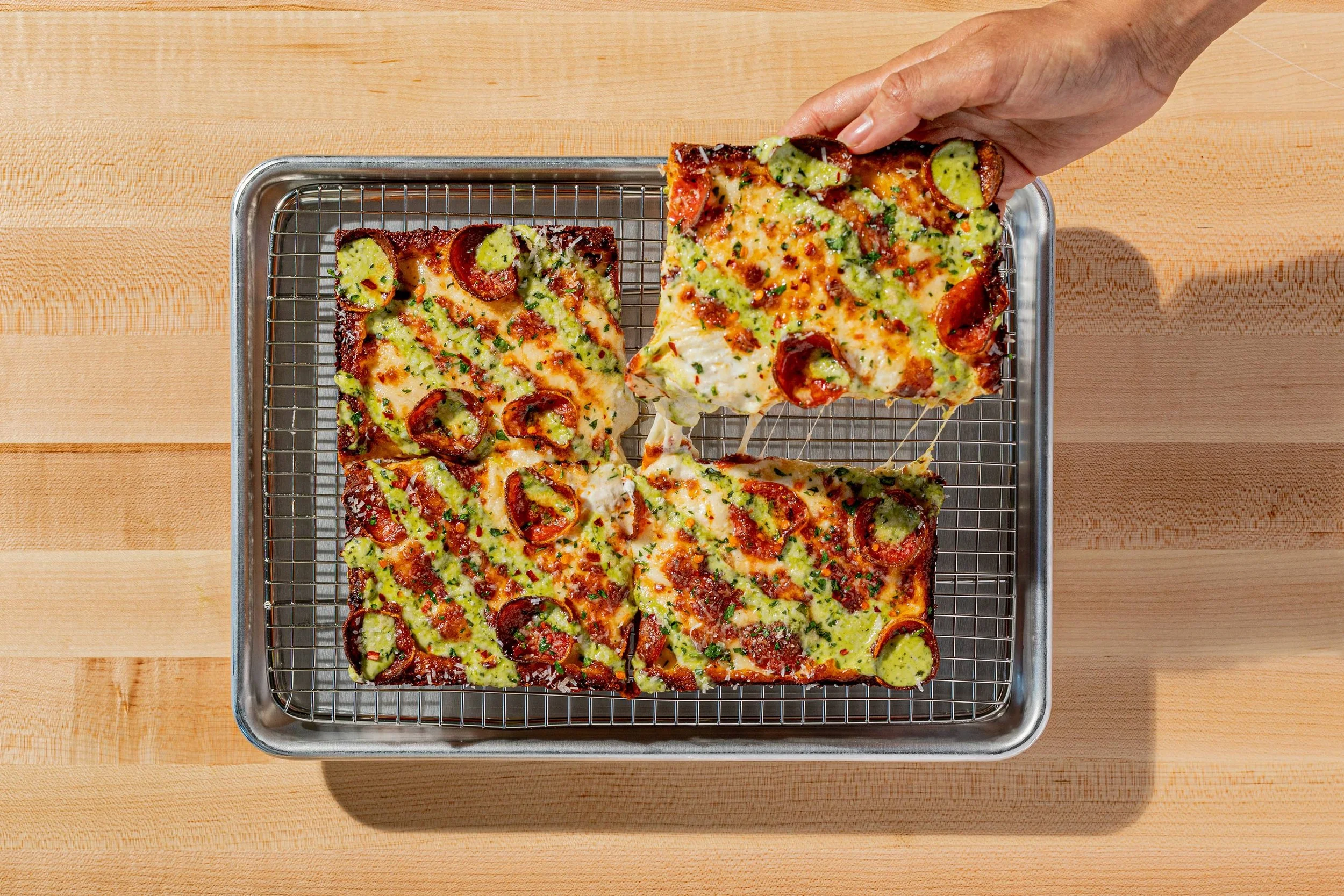 Gorgeous square pizza on a tray.