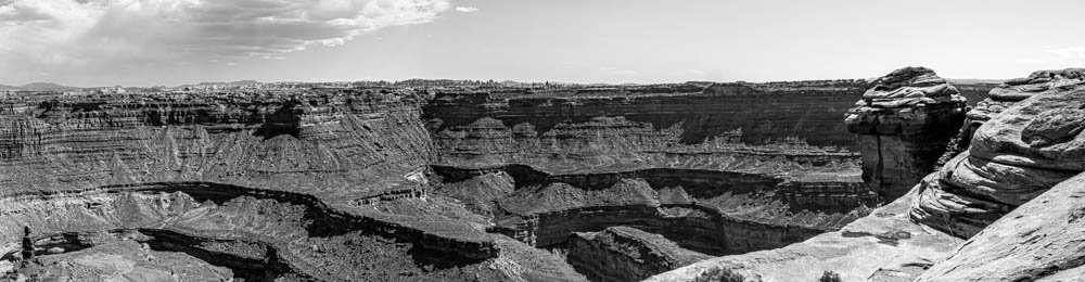 Black and white fine art panoramic landscape photograph of an overwhelming canyon vista stitched from three frames, Needles District, Canyonlands National Park, Moab Utah.