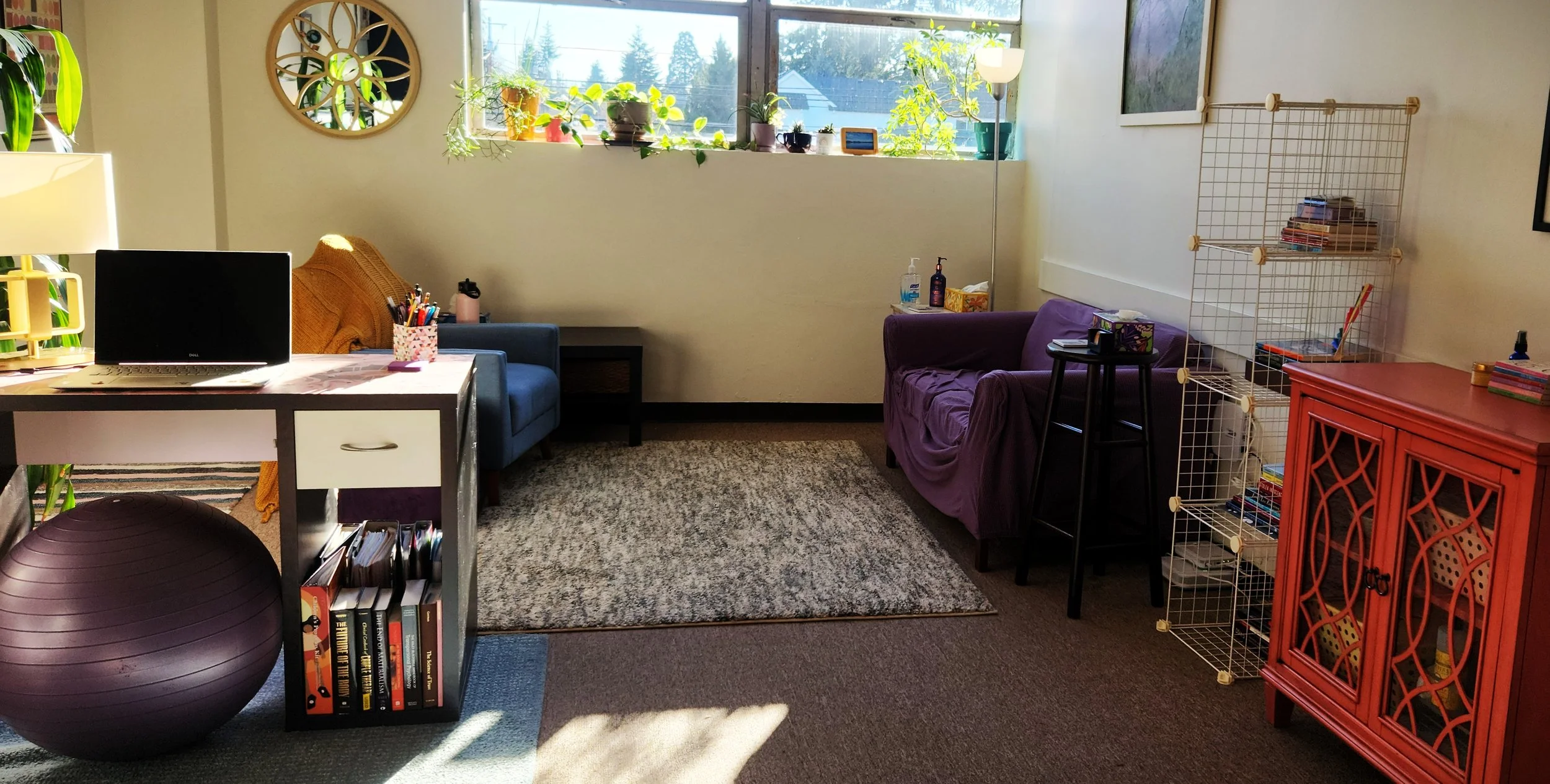 Therapy office with a chair and purple sofa for clients