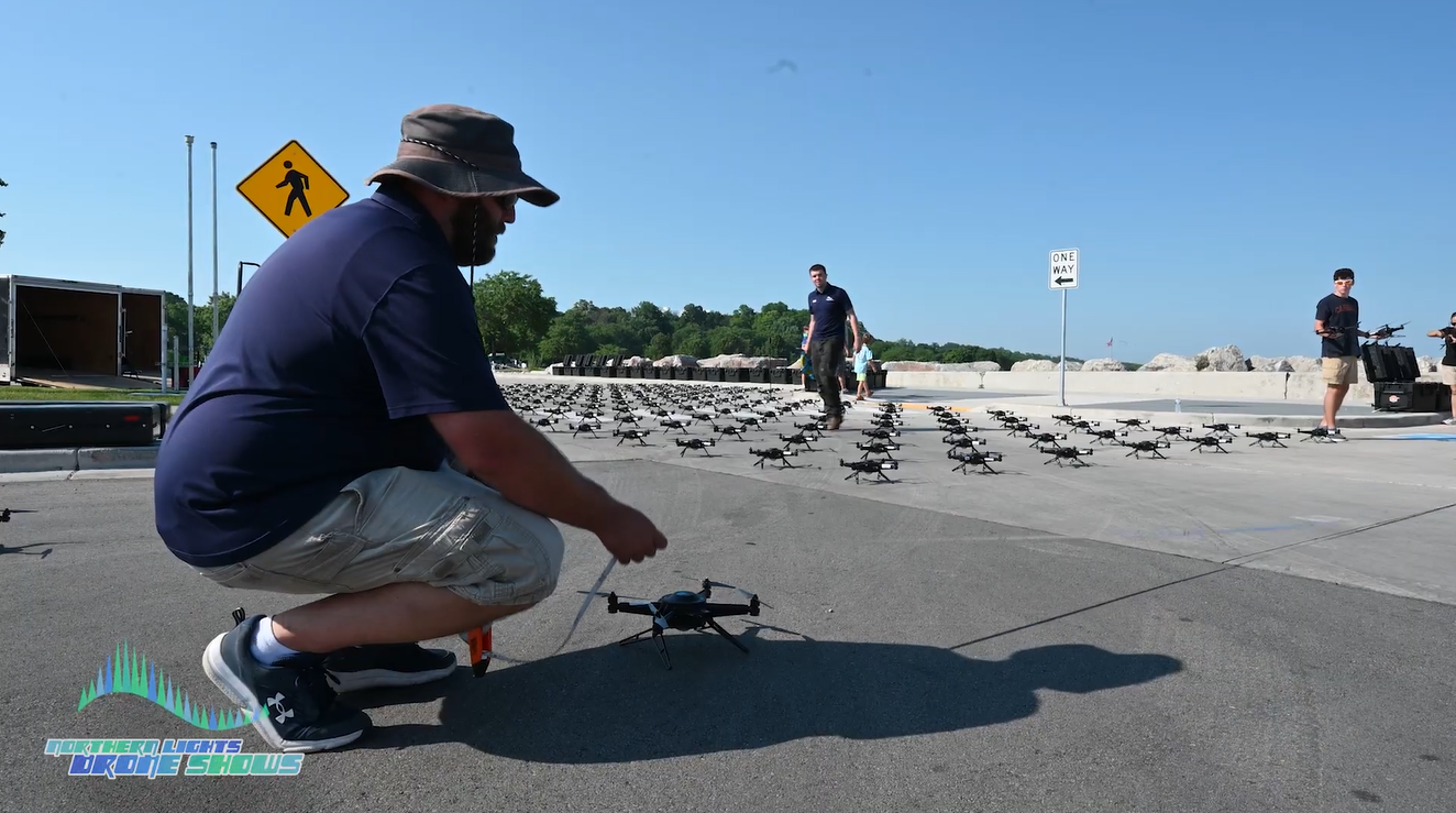 An image depicting an NLDS flight crew member and pilots setting up the drone show in a safe manner.