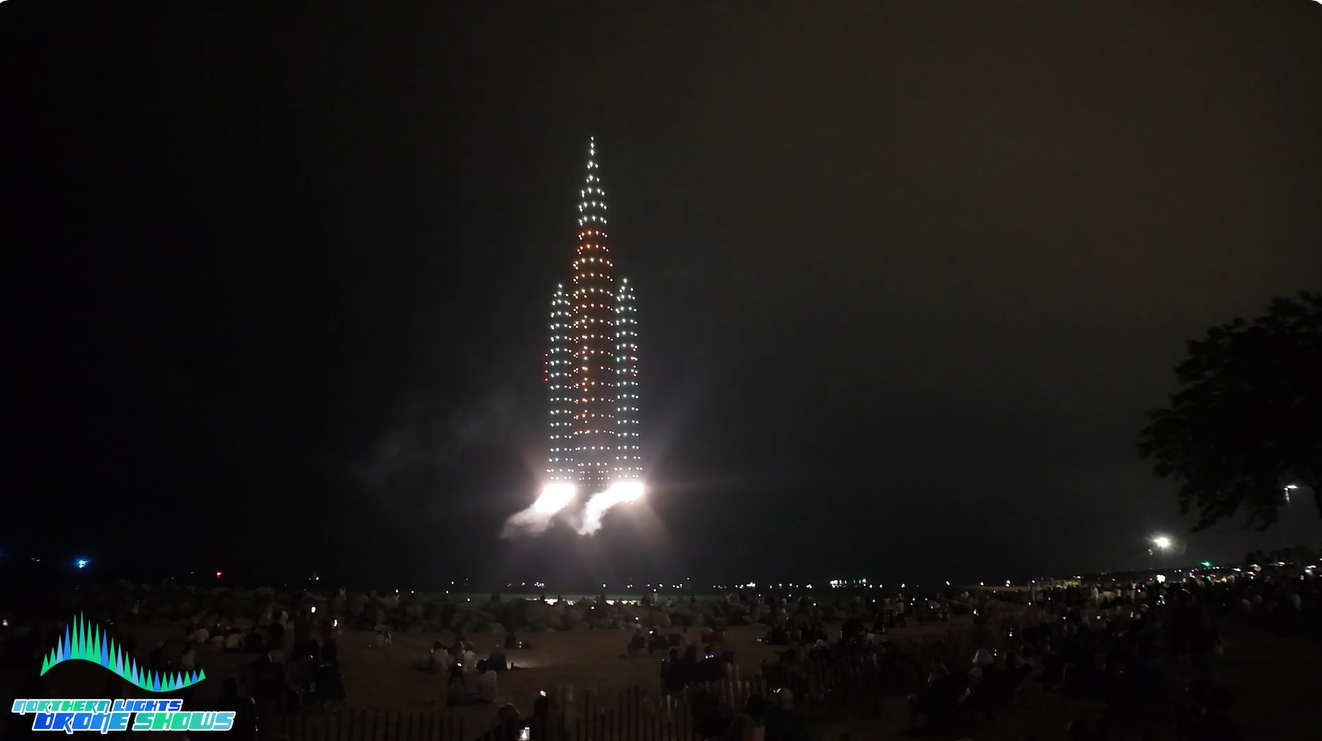 An image from an NLDS drone show depicting a space ship launching with pyro drones as the boosters.