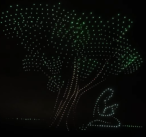 A drone show during a Christian religious community celebration depicting a tree and a woman praying.