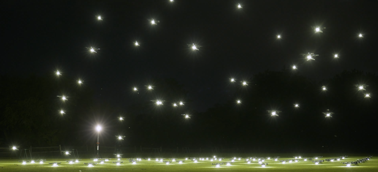 An image depicting NLDS drones taking off from the ground to begin a drone show.