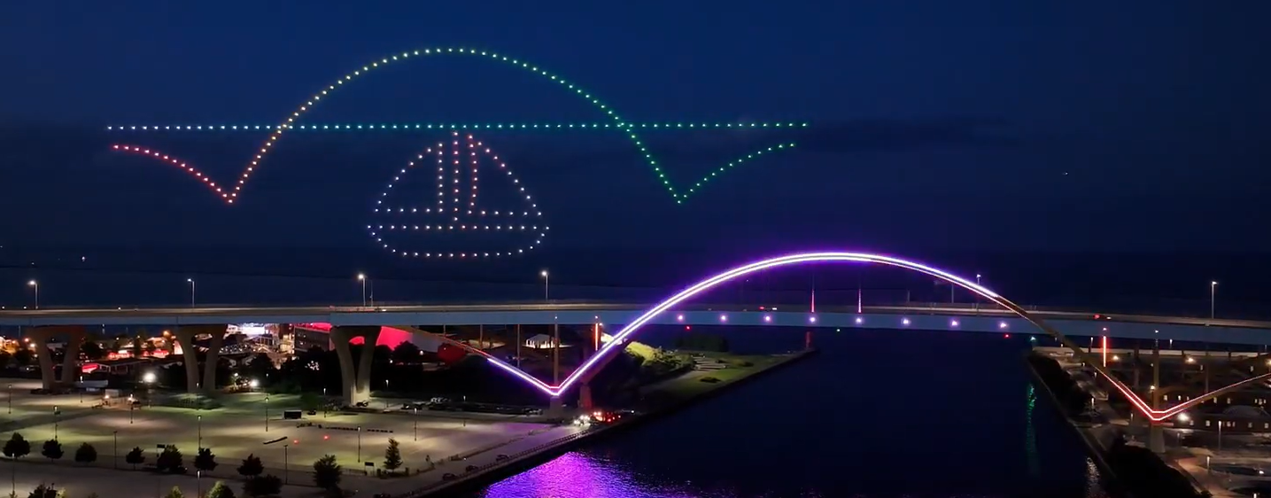 A drone show depicting a local community's bridge and marina, flying over the water.