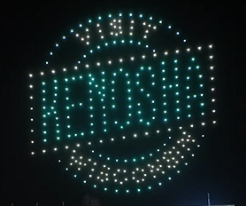 A drone show with the drones arranged to form a "Visit Kenosha, WI" advertisement in the air for a crowd.