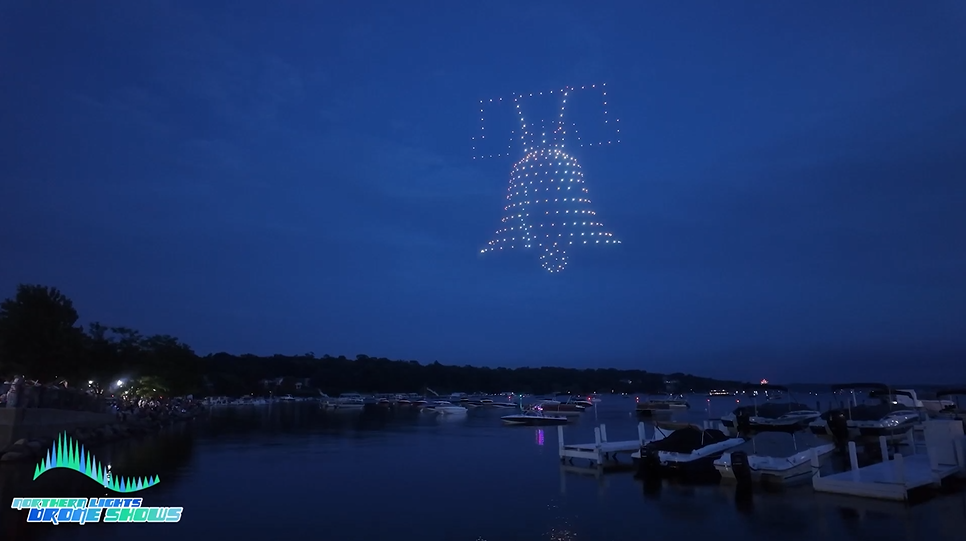 An NLDS drone show depicting the liberty bell ringing above a marina for 4th of July Spectators.