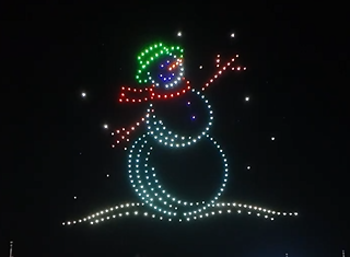 Drones outlining the shape of a snowman waving to the audience during a custom drone show.