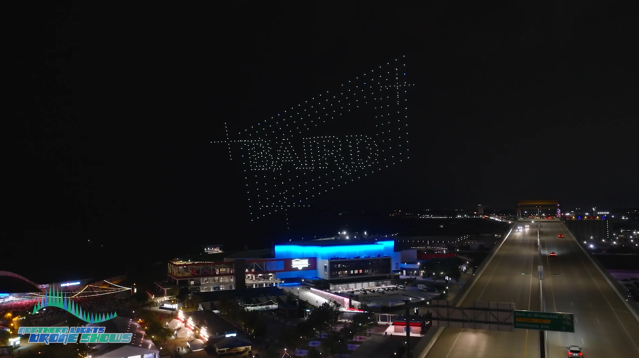 An image depicting a Baird logo during a corporate event at night.