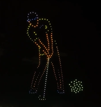 A drone show depicting a golfer hitting a ball above spectators.