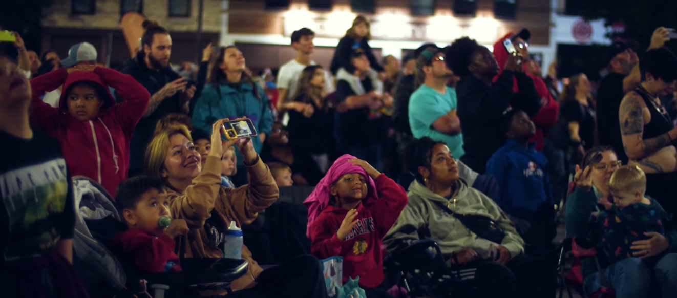 An image depicting a crowd of spectators watching an NLDS drone show.