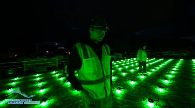 An image from before an NLDS drone show which depicts a ground crew member performing safety inspections.