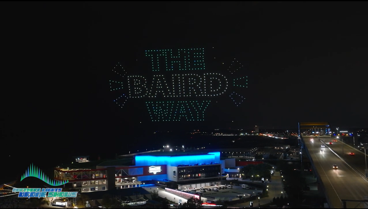 An image from an NLDS drone show depicting a brand's logo in the sky above a crowd.
