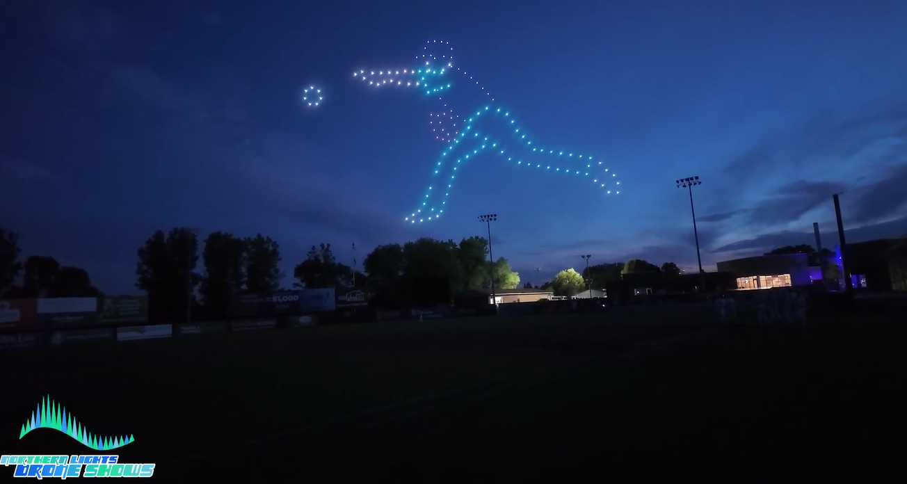 An image depicting a drone show taking the form of a baseball player throwing a ball that really moves.