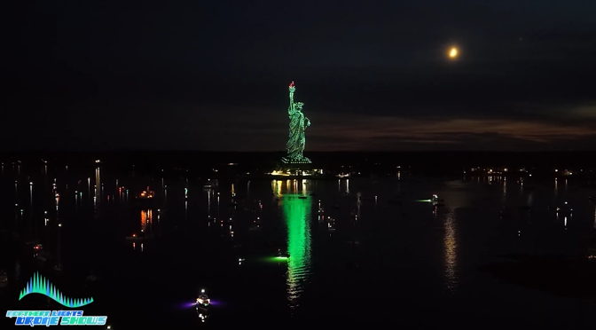 An image of an NLDS drone show depicting the Statue of Liberty above a lake in Maine.
