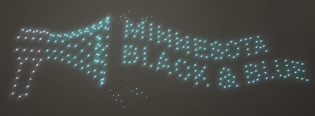 Drones arranged in a drone show to depict a sports team's slogan and catchphrase in flight.