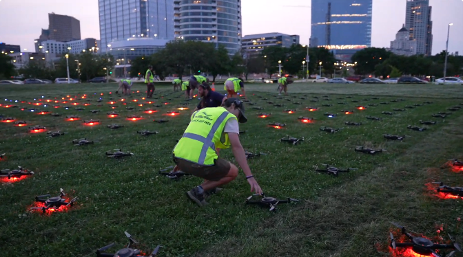 An image from an NLDS drone show which depicts a ground crew member setting up drones in a safe way.