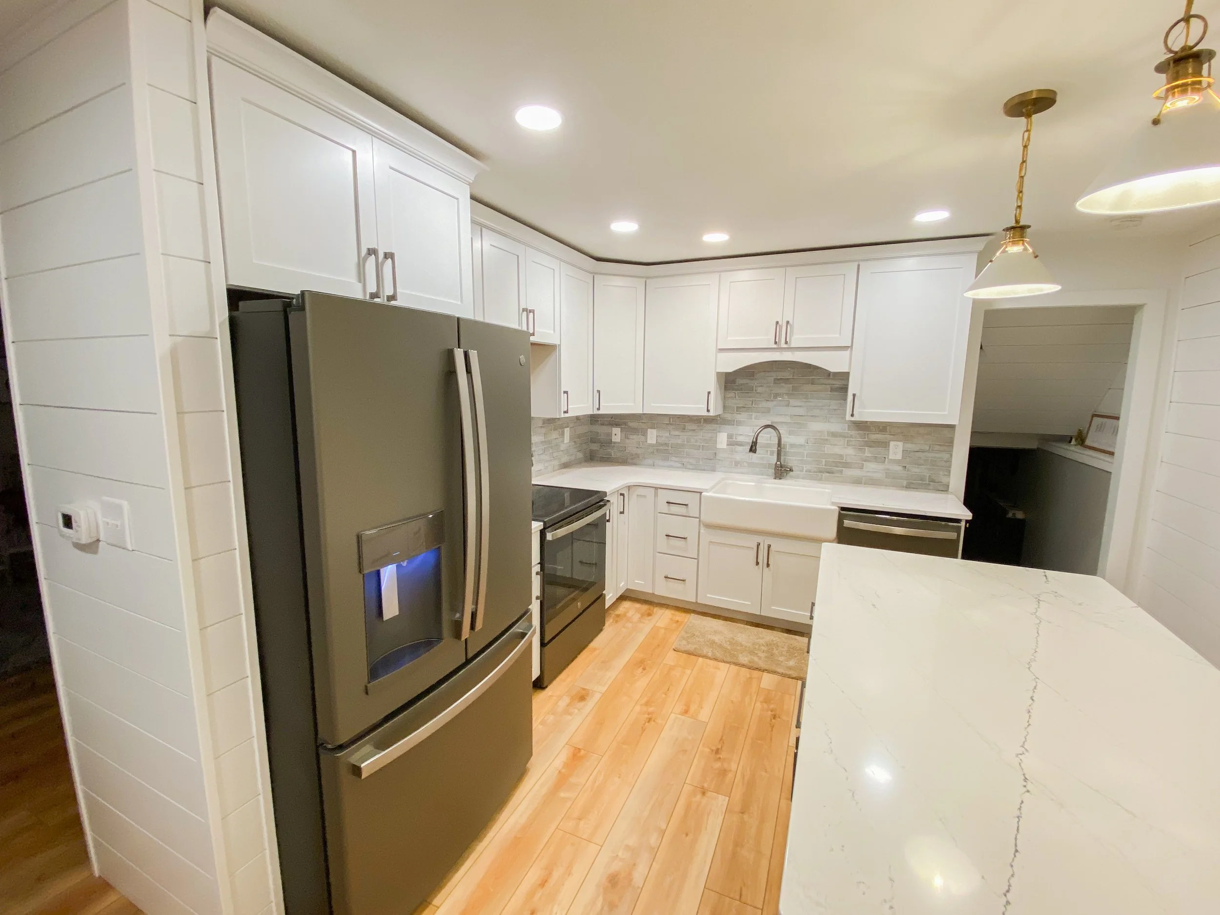 Cabinets, countertops, lighting, shiplap, backsplash, and flooring.