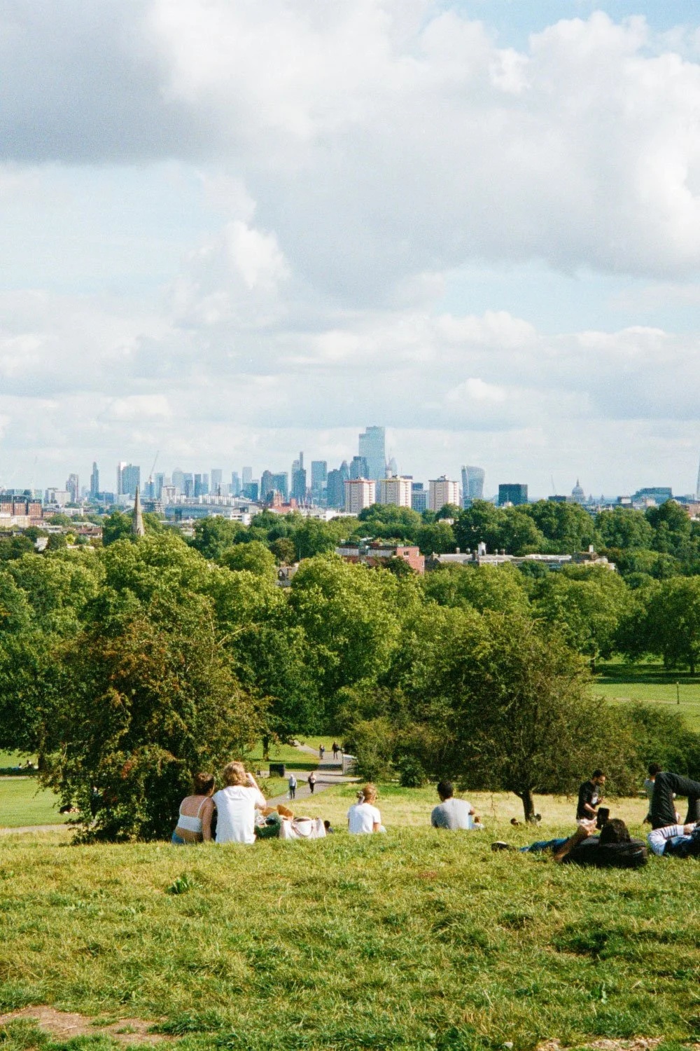 People sitting looking at the view if London from Primrose Hill