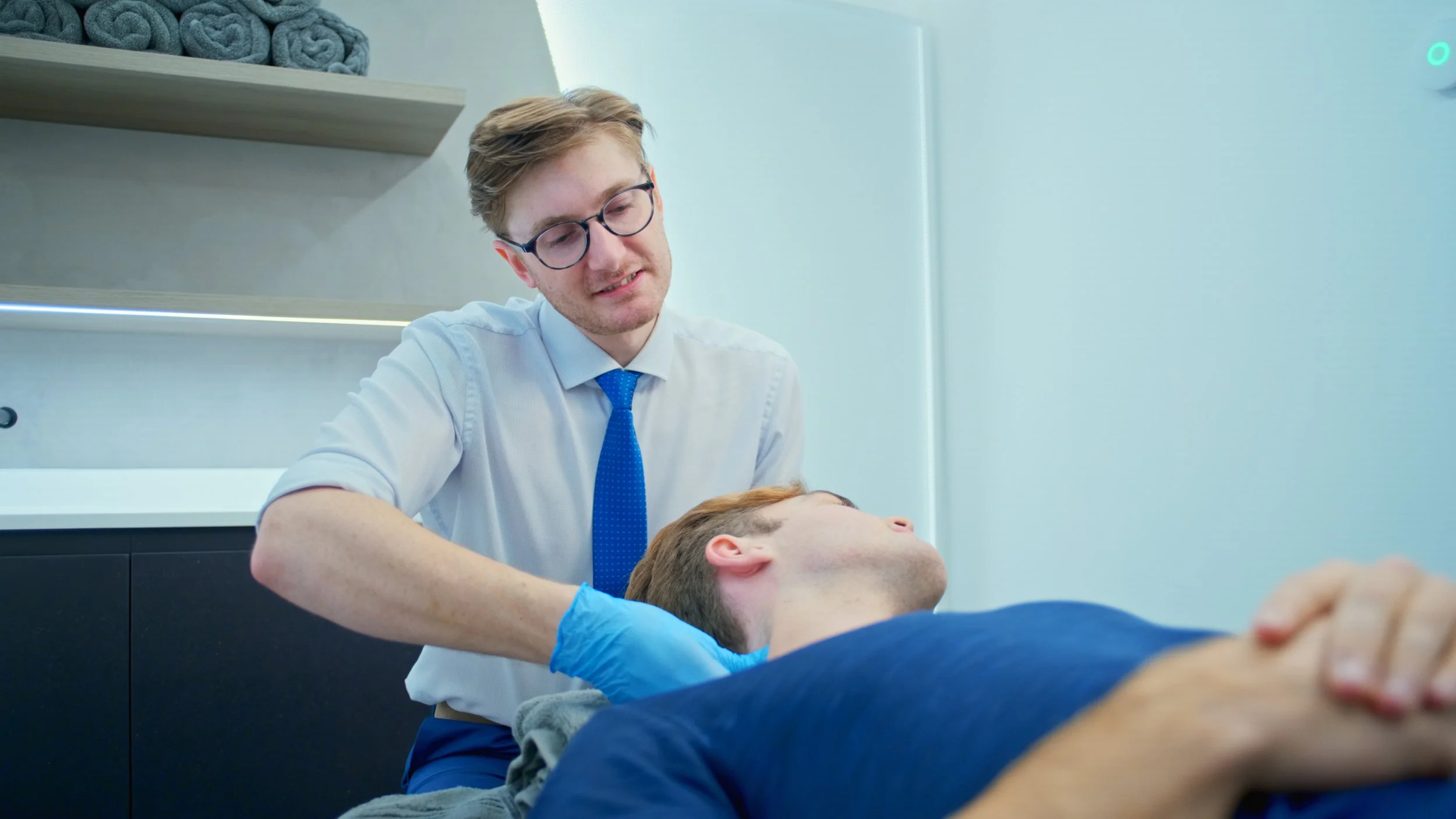 A patient is having their neck examined