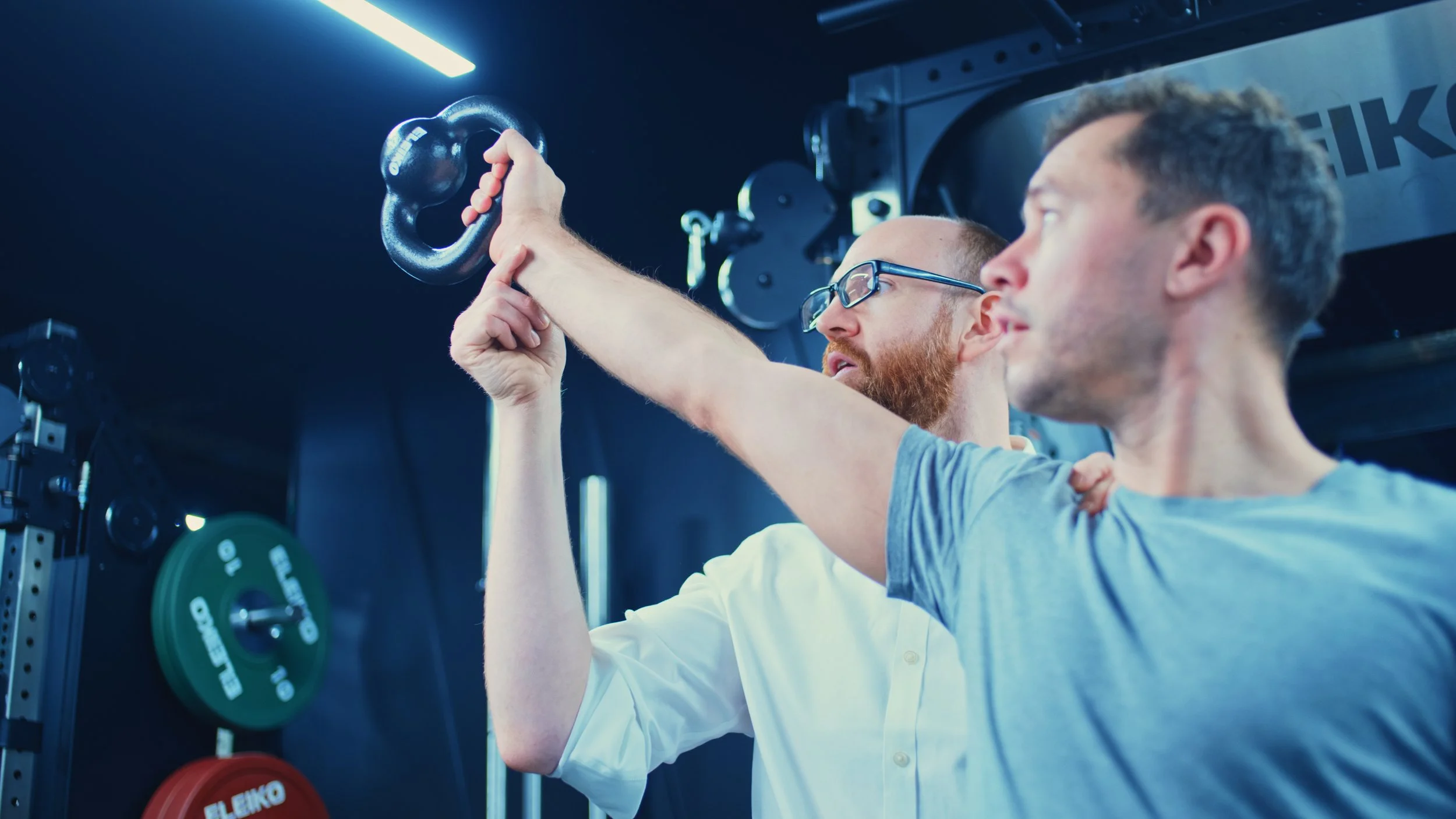 Patient completing sports injury rehabilitation in the gym as part of a structured return-to-sport programme following a shoulder injury under the guidance of a rehabilitation specialist