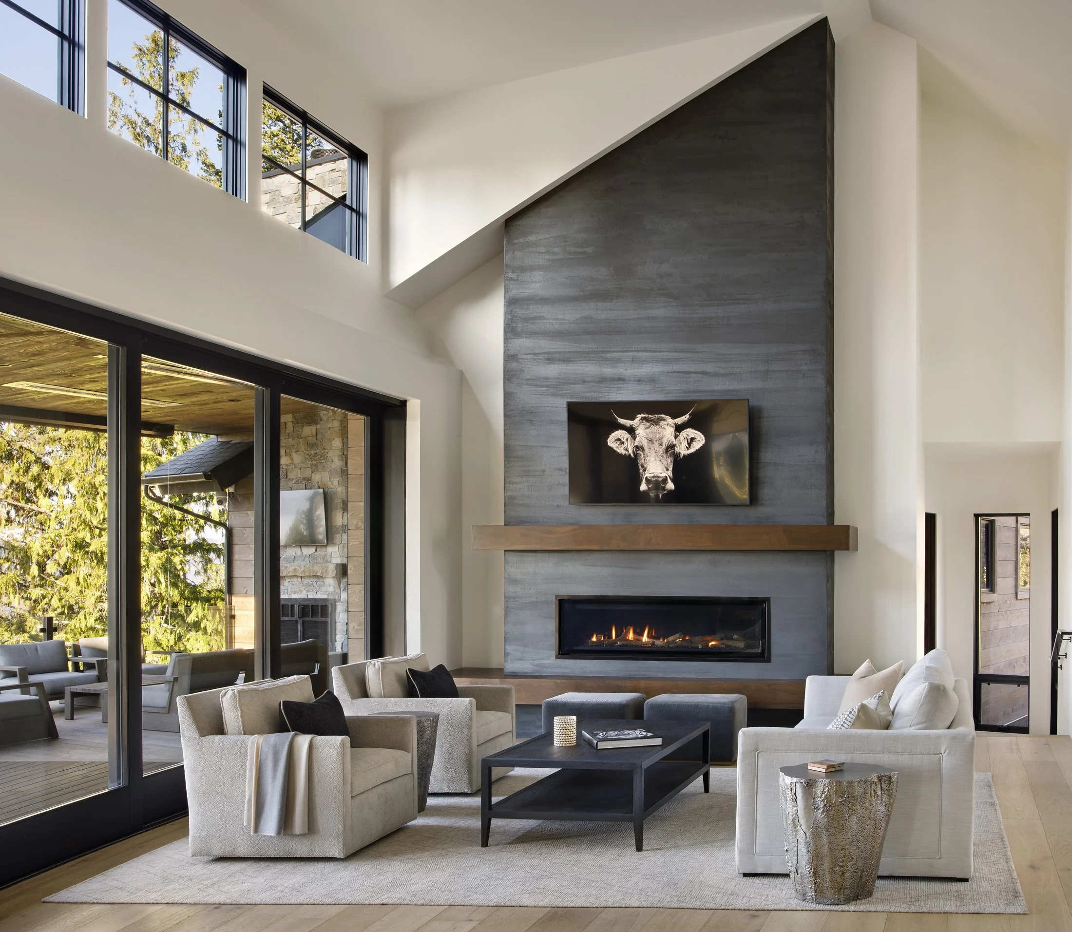 Mountain Modern living room with floor to ceiling windows and fire place.