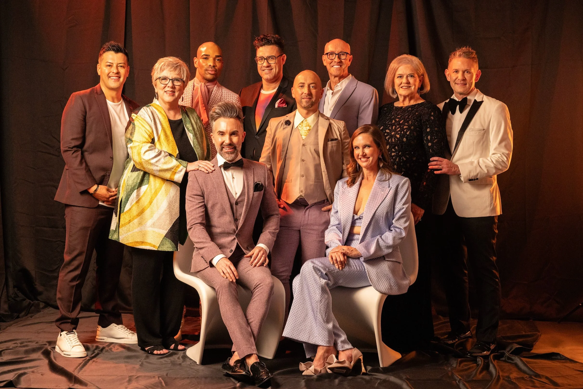 Team portrait with colleagues standing and seated together in a warmly lit interior.