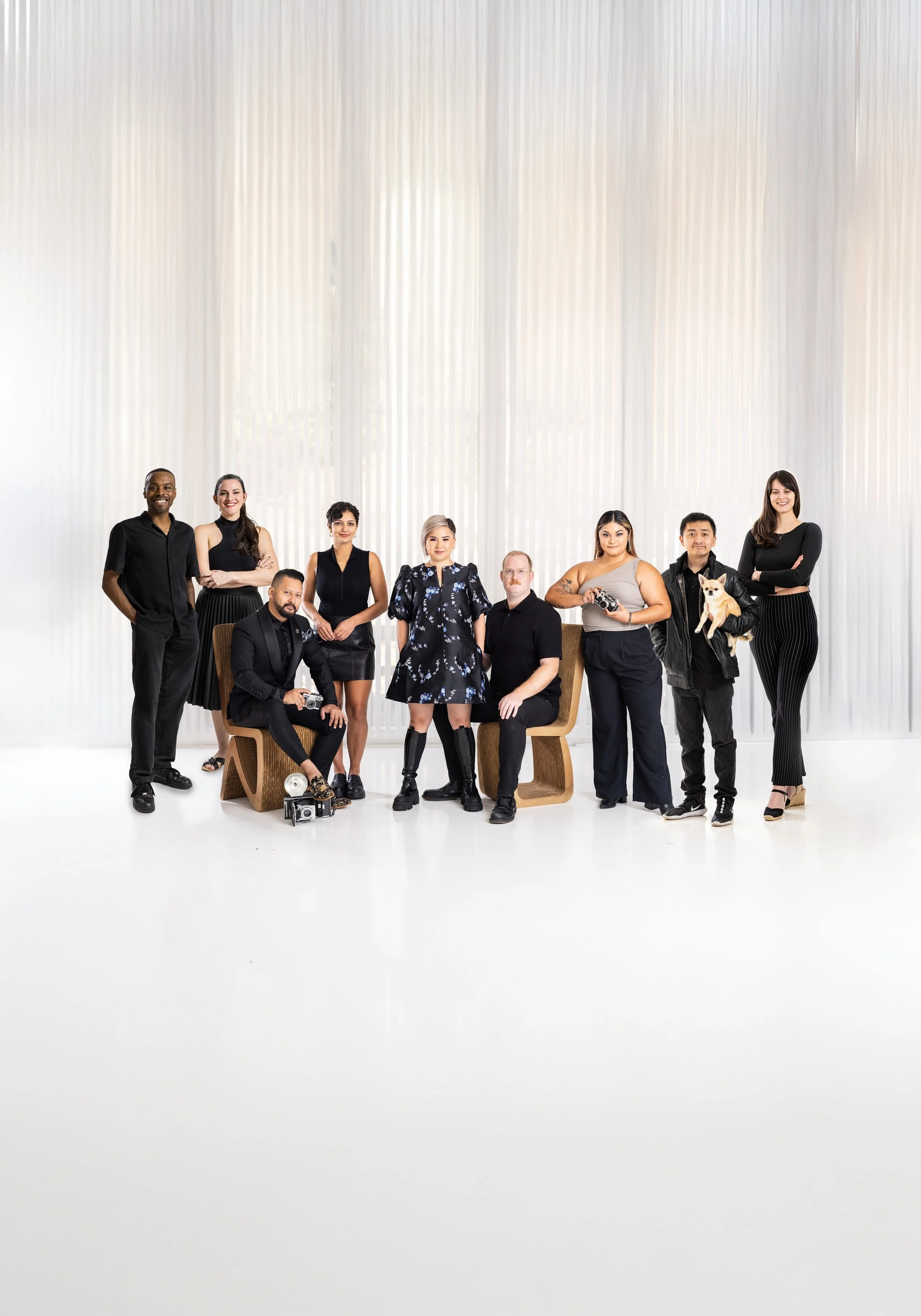 Kathy Tran Creatives team posing together in a bright studio with white curtains.