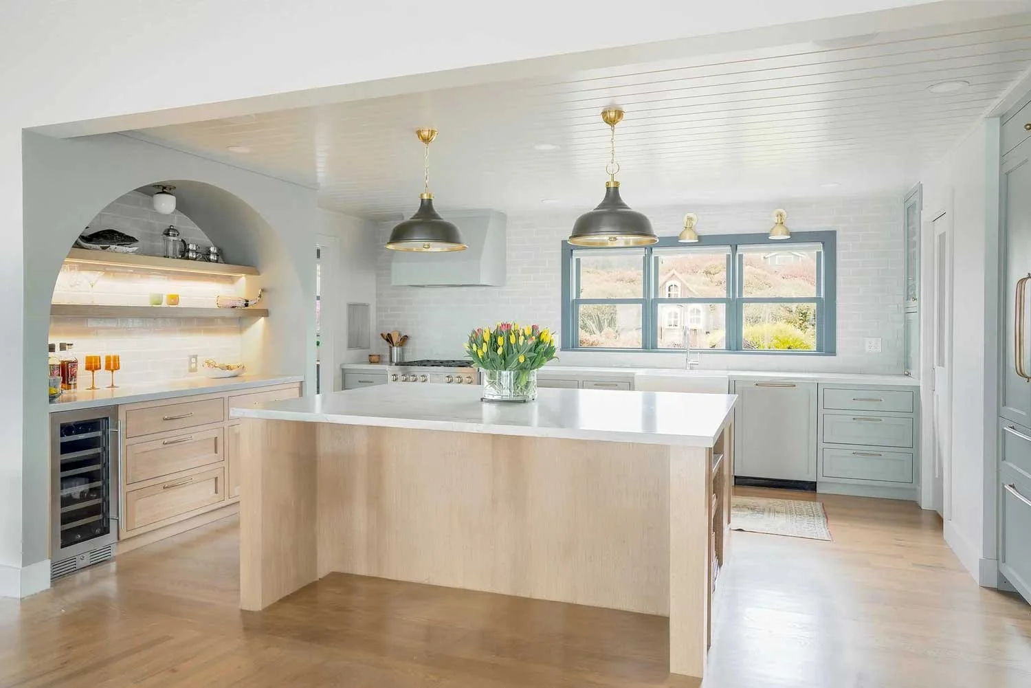 Island bar made from light colored wood and with a slightly white marbel top 