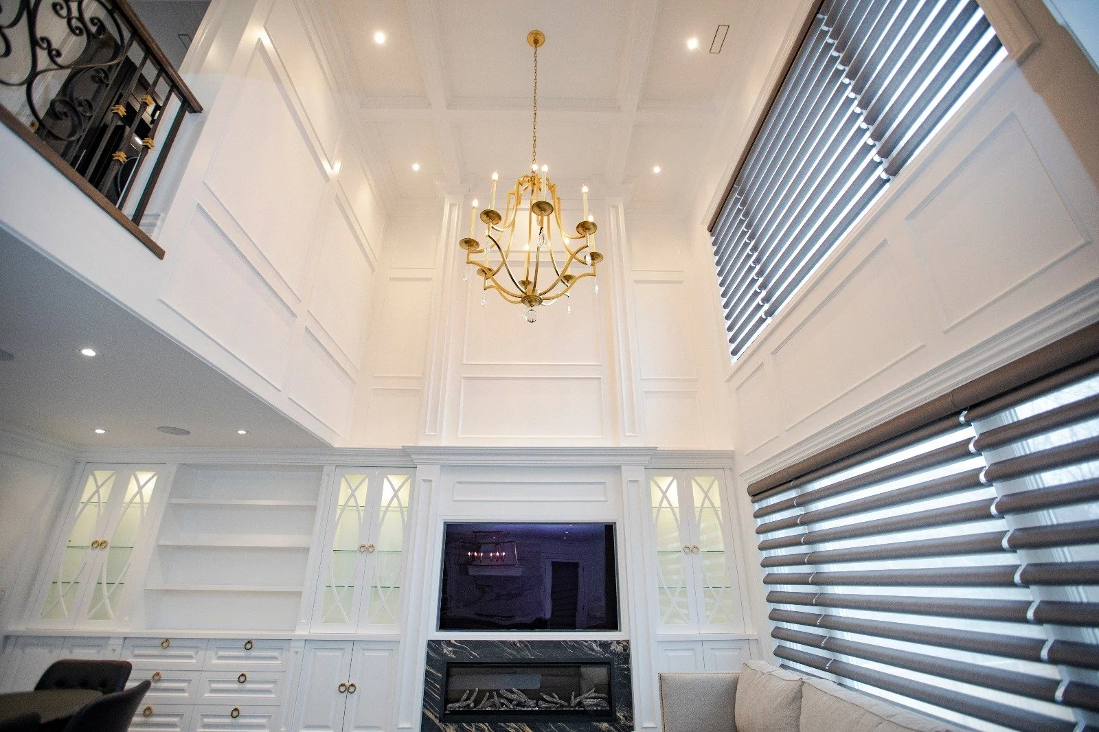 Luxurious living room designed by Summit-X, featuring a grand chandelier that accentuates the high ceilings and elegant furnishings.