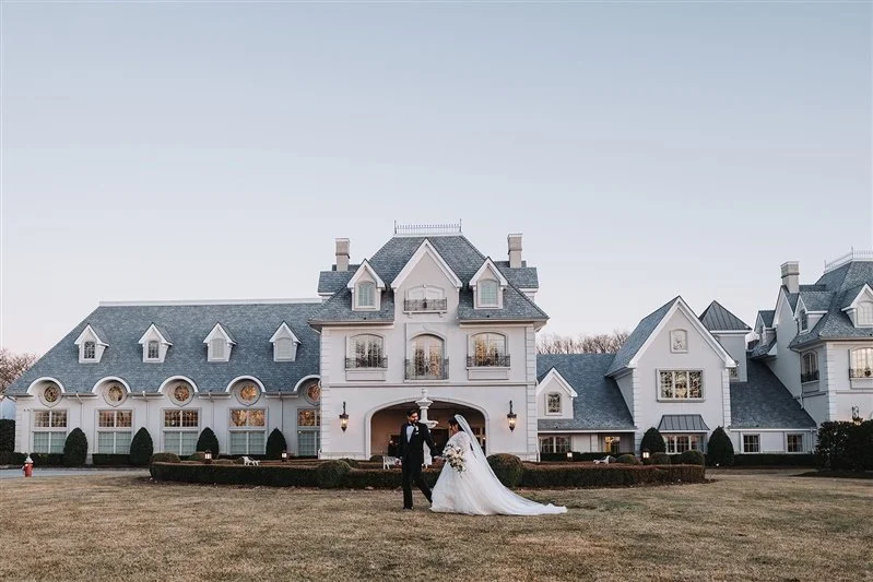 Bride and groom in front of estate venue during wedding portraits.