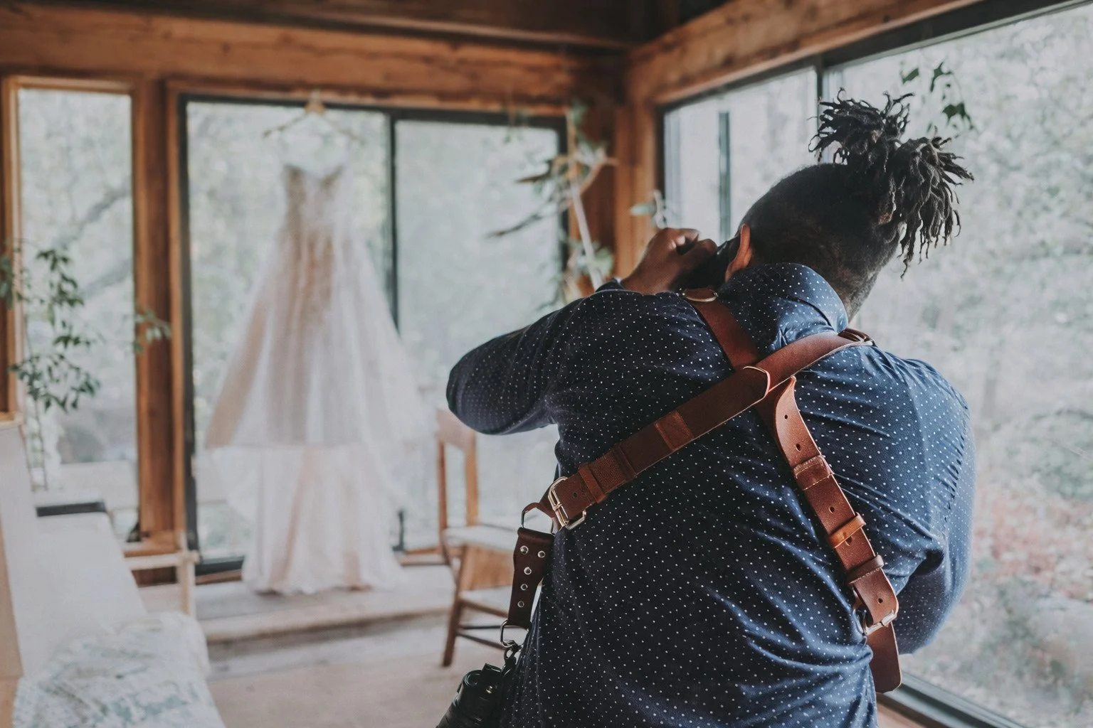 Wedding photographer photographing a wedding dress in natural light.