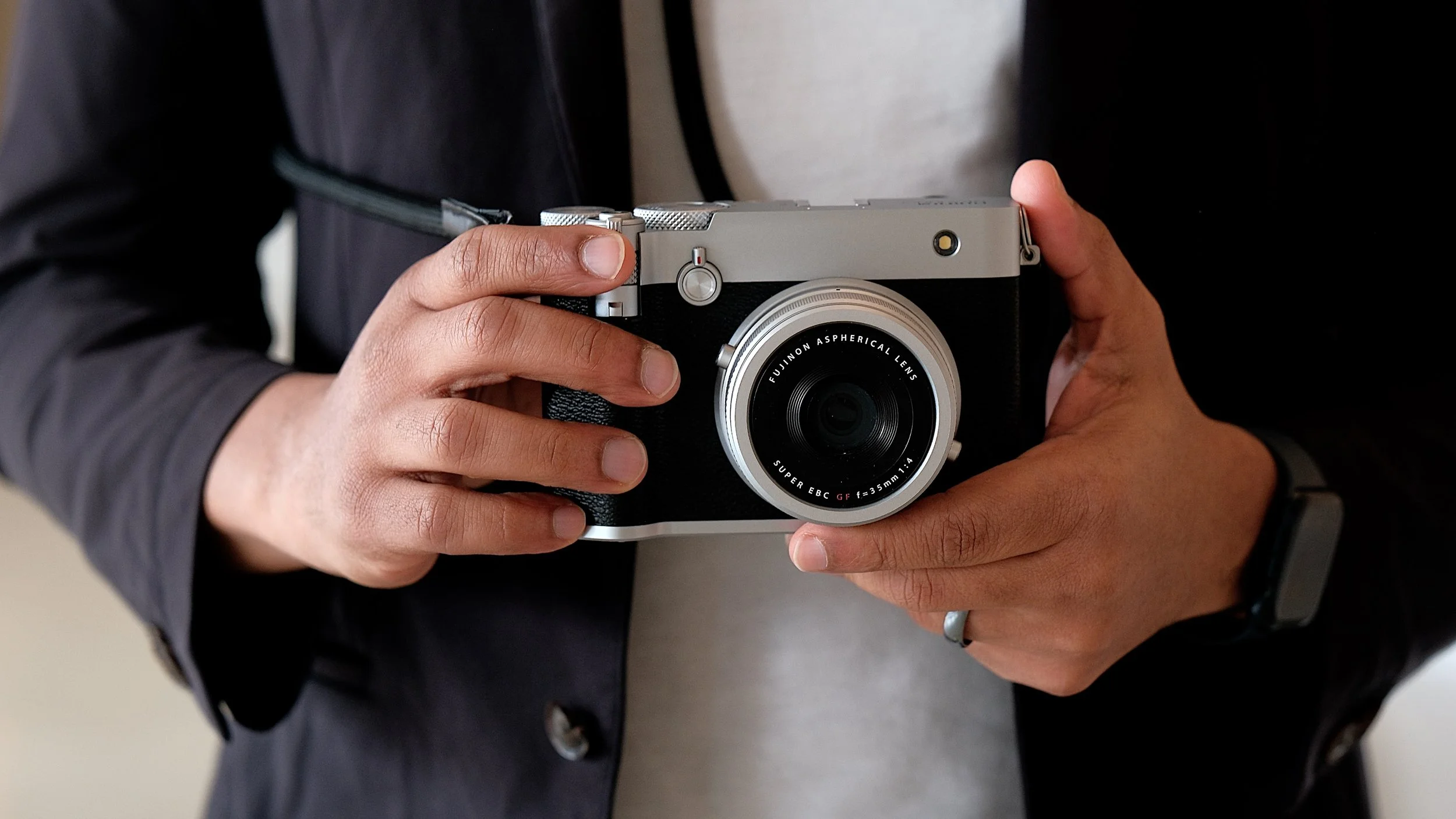 Close-up of John holding a Fujifilm camera the GFX 100 RF.