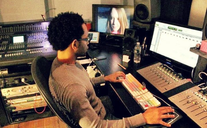 John Branch IV sitting in an audio production studio mixing audio