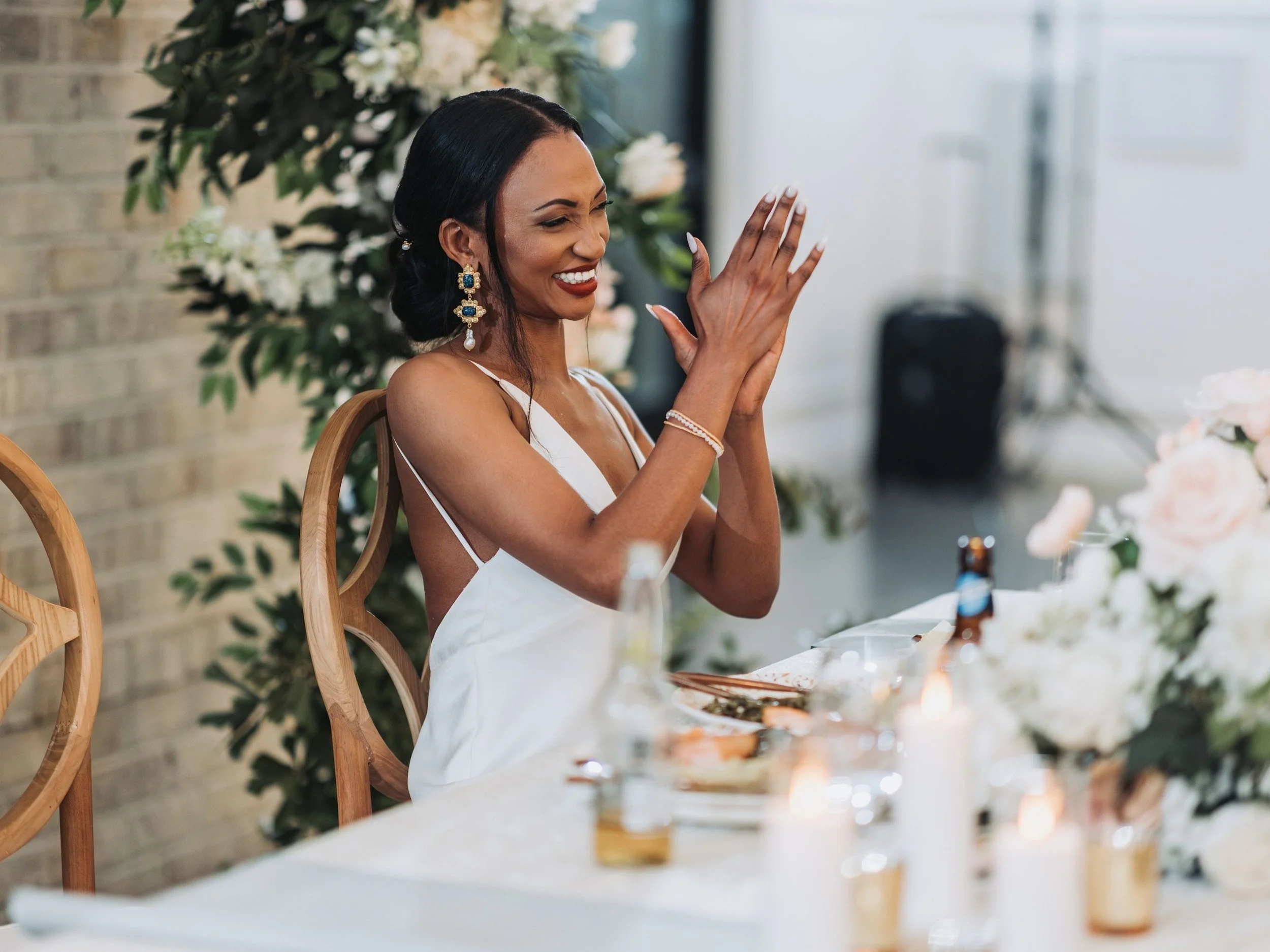 Bride reacting during wedding speeches at the reception.