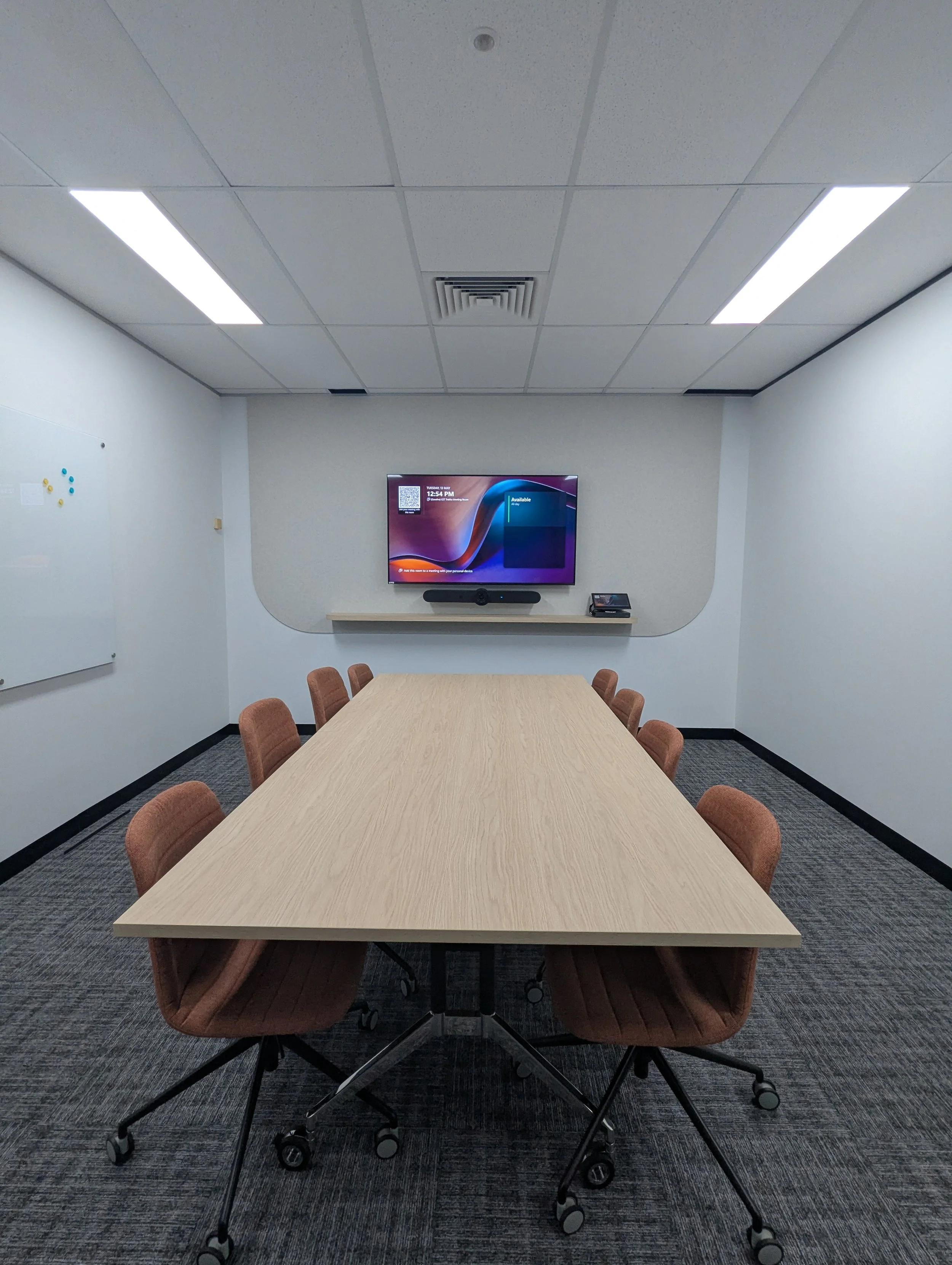 Corporate Microsoft Teams meeting room with wall-mounted display and integrated AV presentation system with Logitech Rally Bar