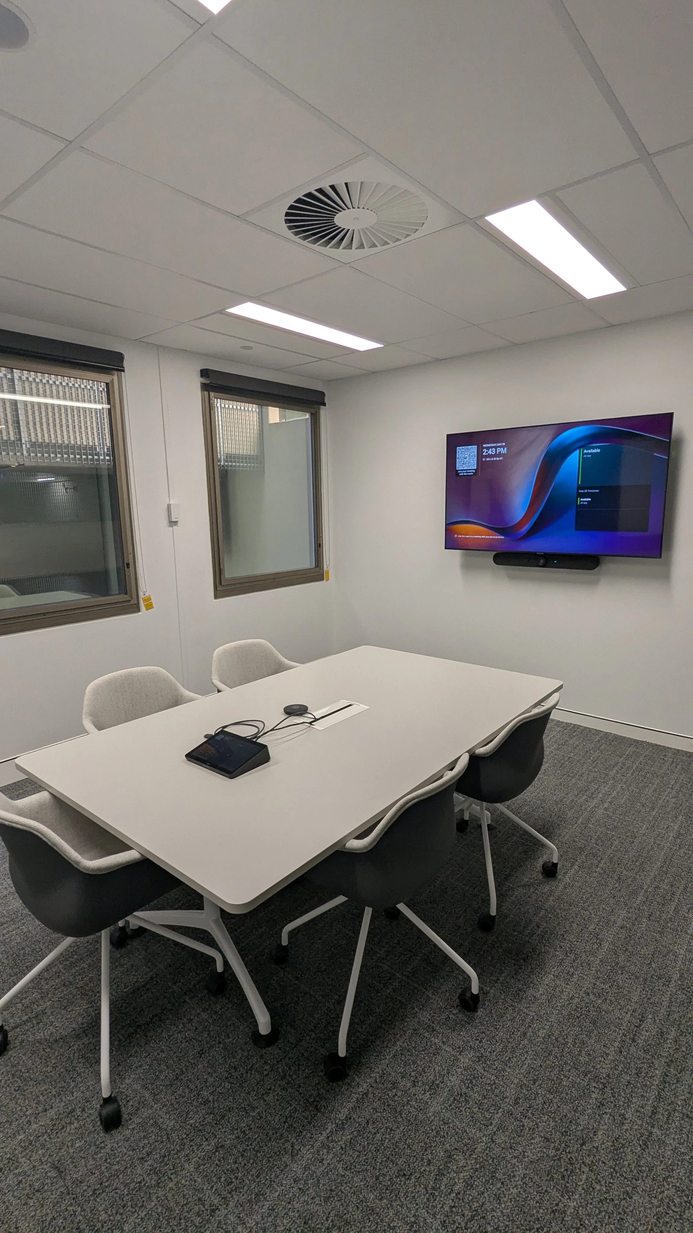 Corporate dual screen modern meeting room with Microsoft Teams Rooms conferencing system.
