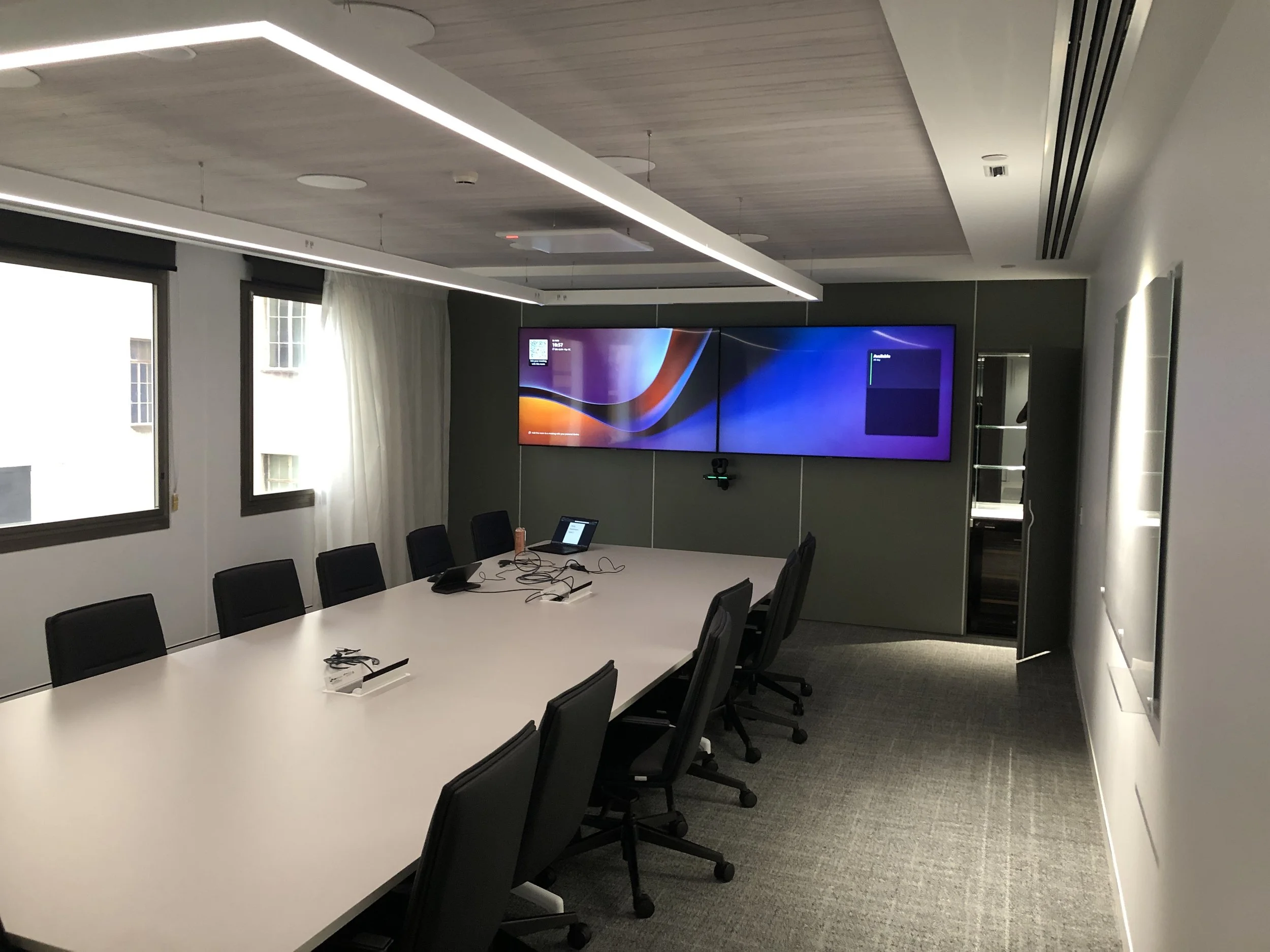 Corporate dual screen modern boardroom with Microsoft Teams Rooms conferencing system.